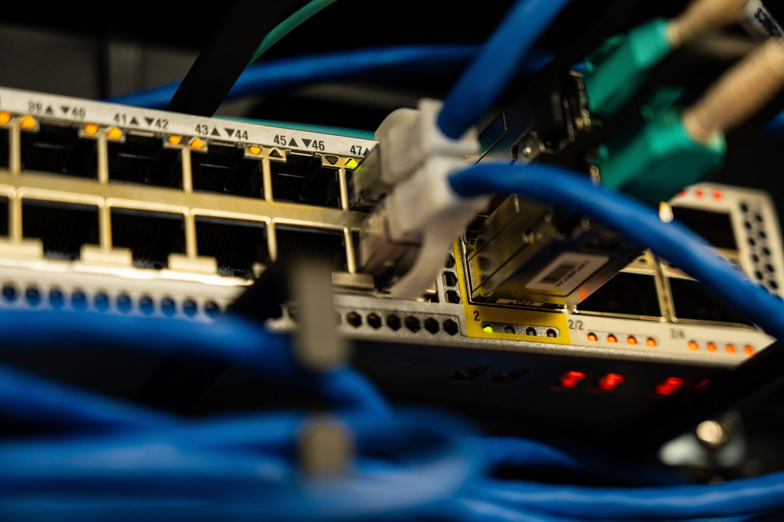 Close-up of ethernet cables and status lights plugged into a network switch