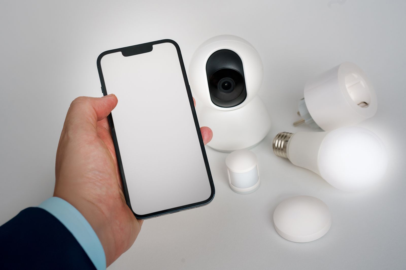 A person using a smart home app on a smartphone to control connected devices