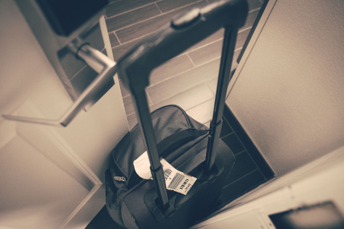 Suitcase sitting in a hotel room doorway during a trip