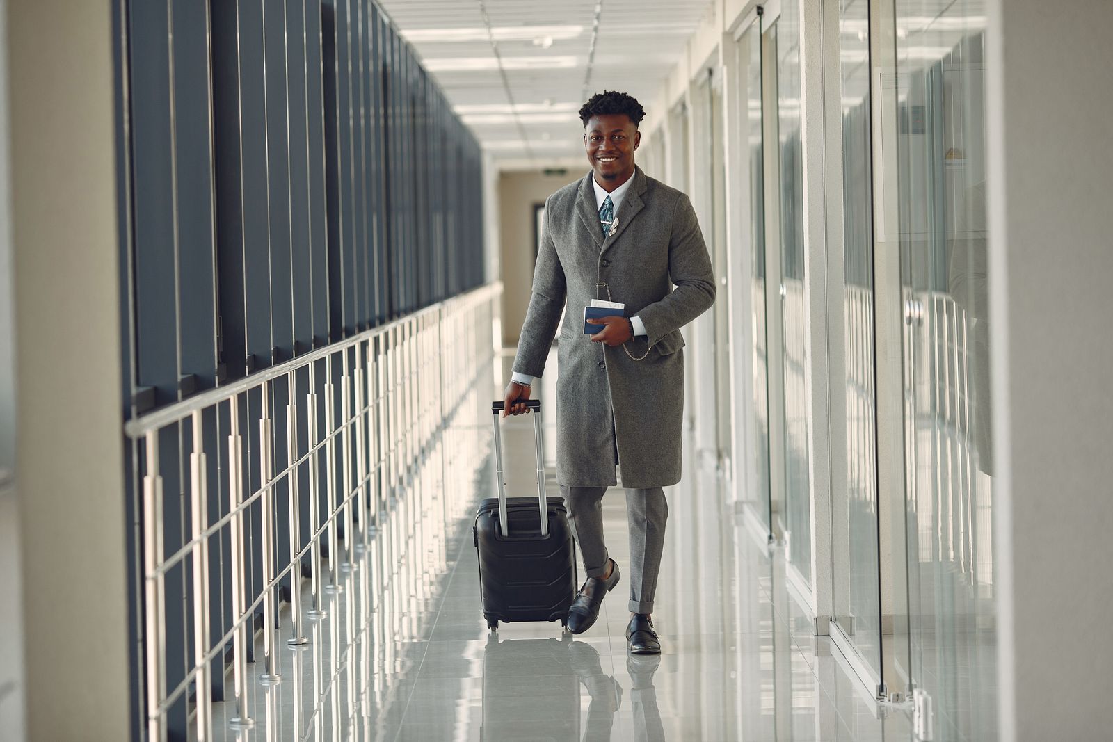 Traveler walking through an airport corridor with a wheeled suitcase