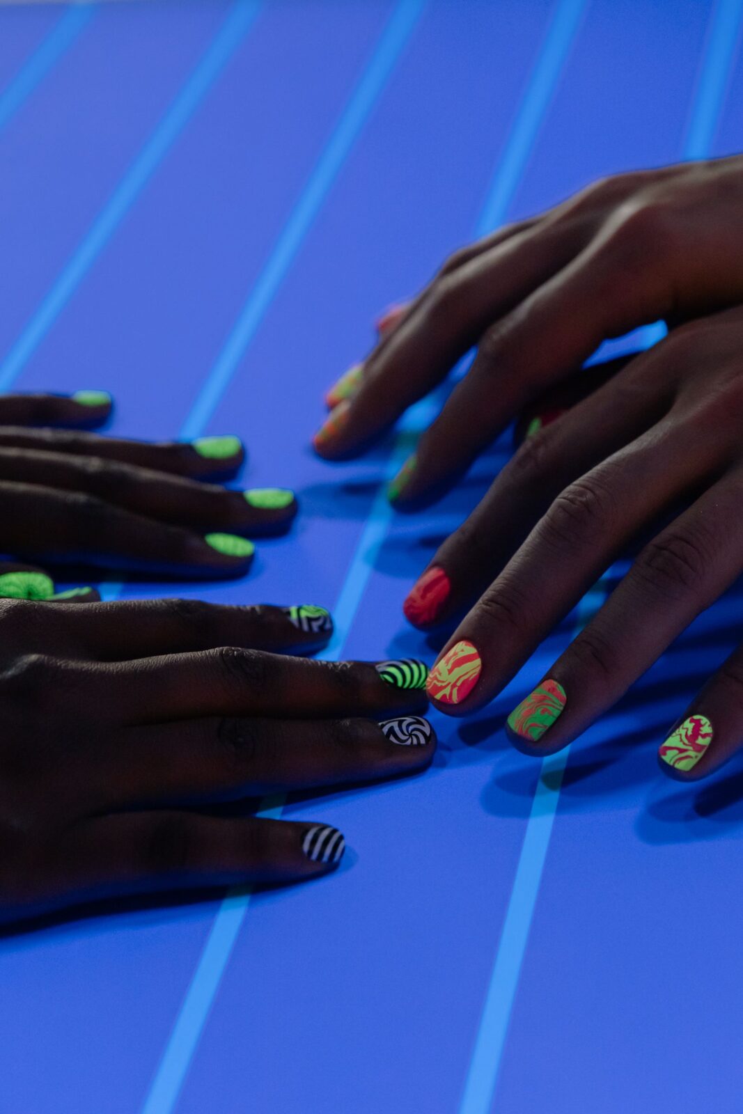 Close-up of hands with colorful glossy manicured nails, illustrating chip-resistant clean nail polish finishes