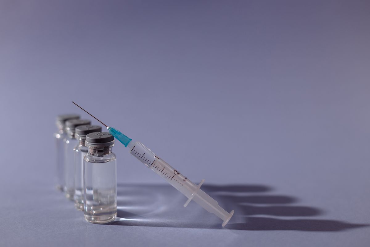 Syringe and medication vials laid out on a table
