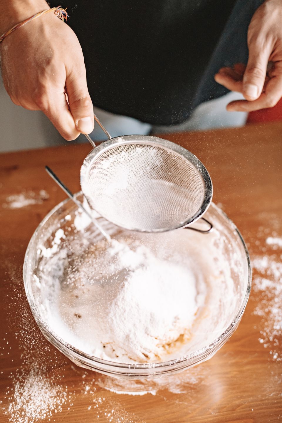 Fine powder being sifted into a glass bowl