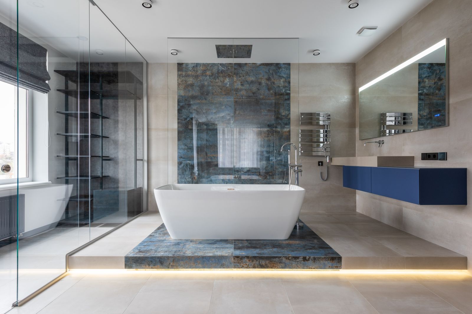 Modern bathroom interior with a freestanding tub, gray tile, and chrome fixtures