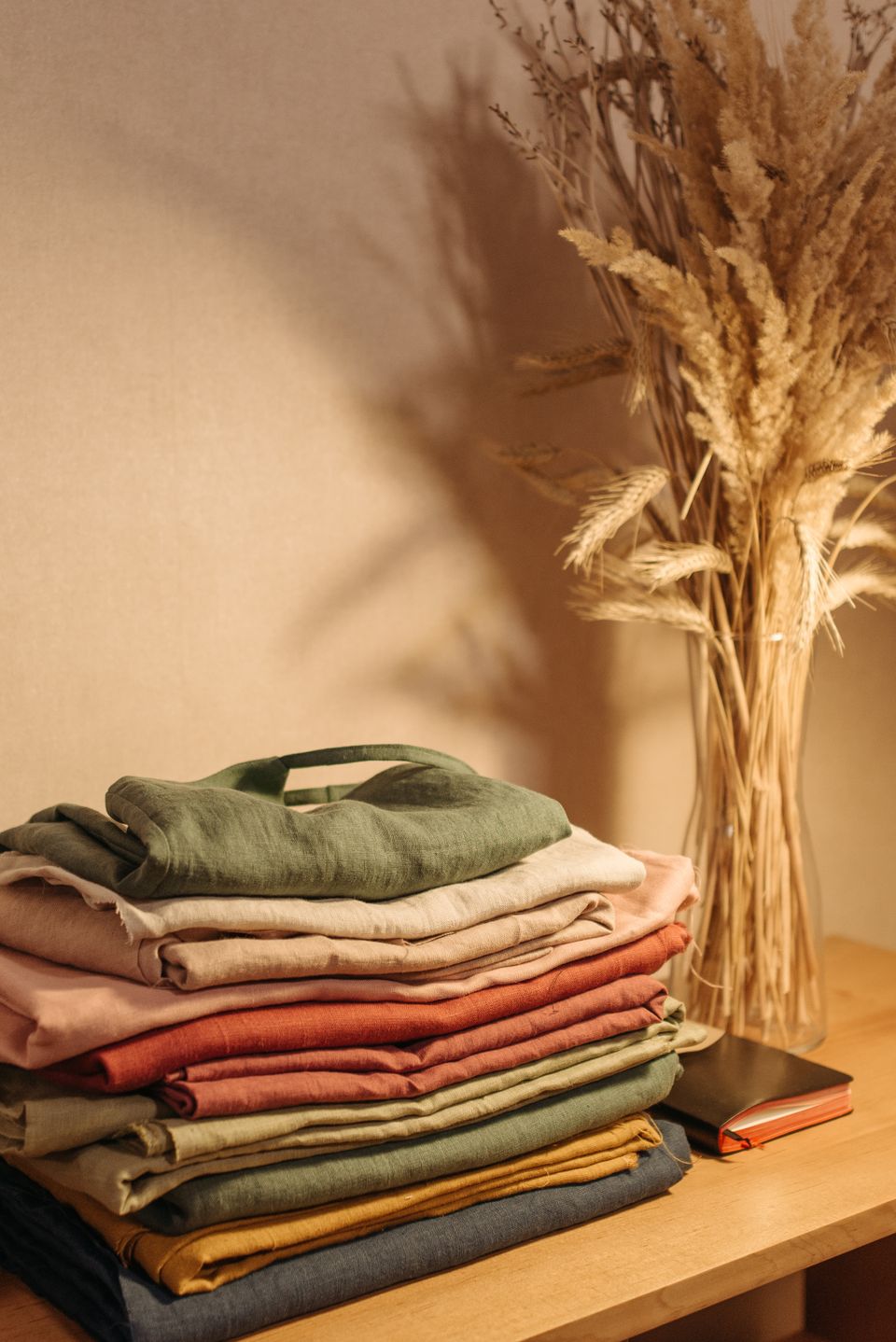 Neatly folded stack of sweaters and clothing in earthy tones, the kind of load a cube shelf has to hold