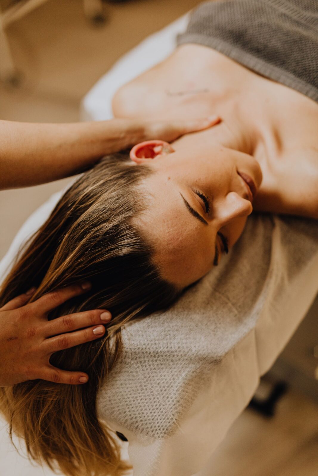Massage therapist using hands to work tension out of a client's neck and shoulder