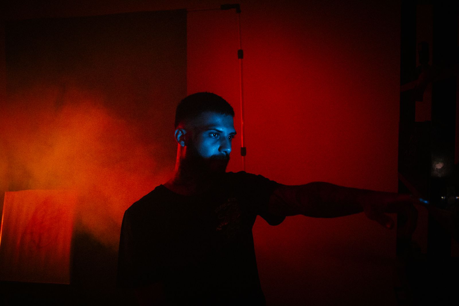 Man setting up a small portable projector in a dark room before movie night