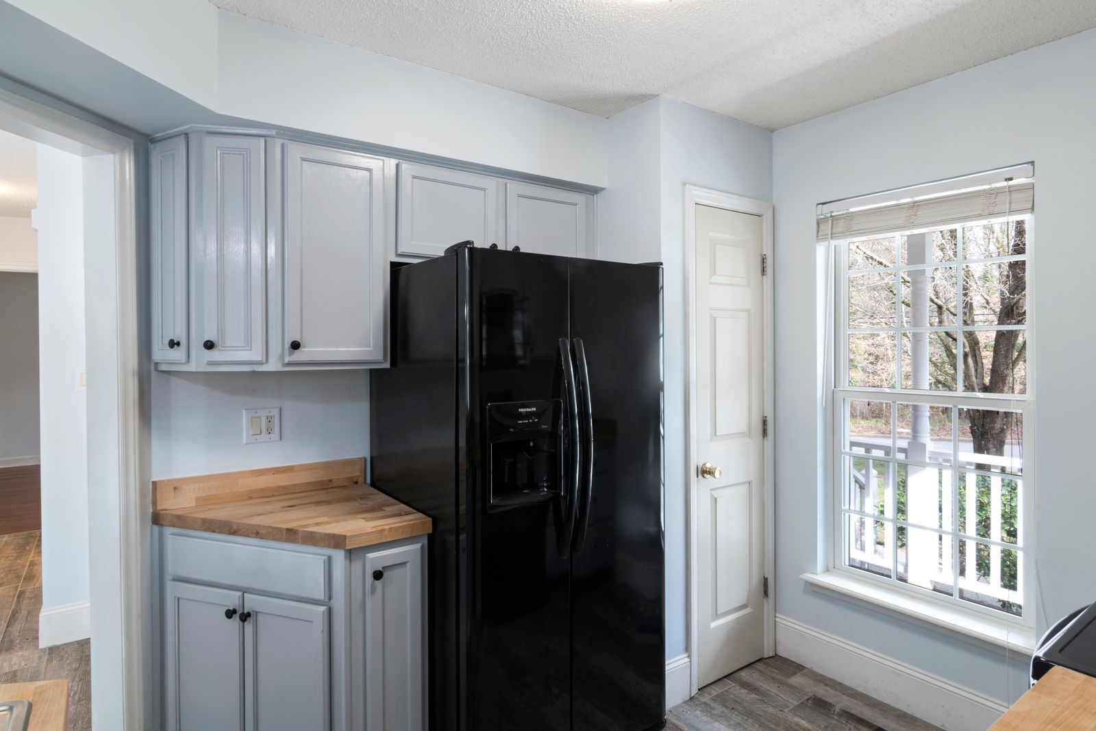 A black refrigerator in a bright apartment kitchen, the kind of appliance a small power station needs to keep running during an outage