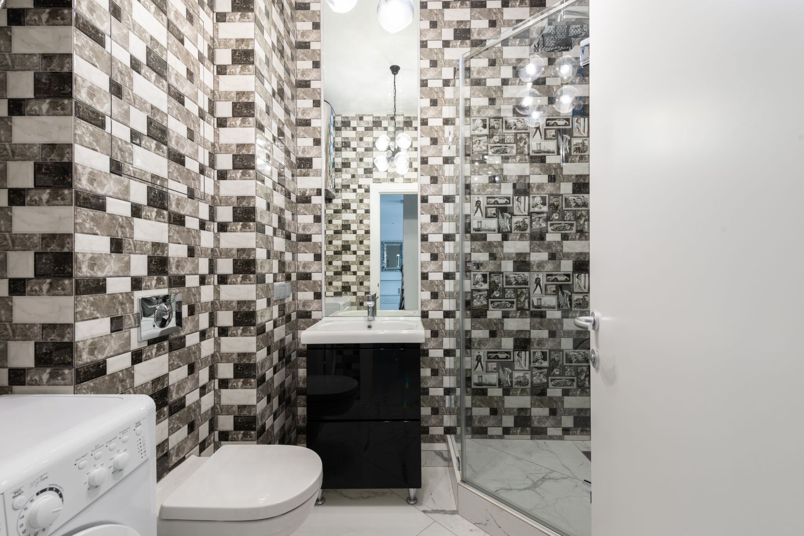 Bright modern bathroom with a wall-mounted toilet, glass shower, and sink