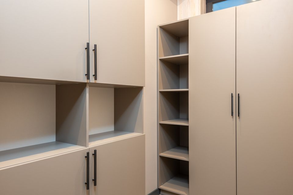 Minimalist built-in shelving unit with empty cube-shaped compartments in a neutral bedroom