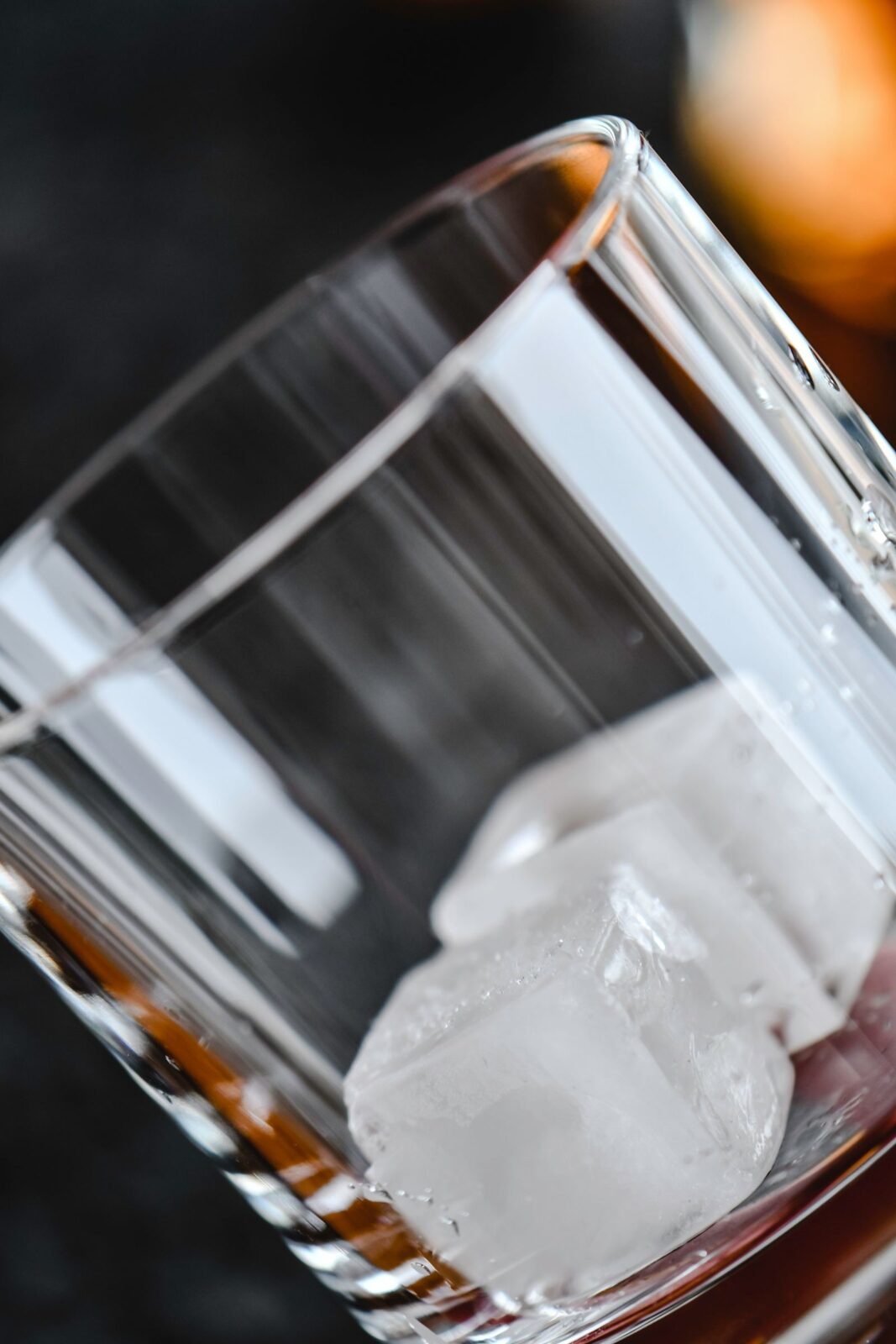 Two cloudy, rectangular ice cubes in a heavy-bottomed rocks glass