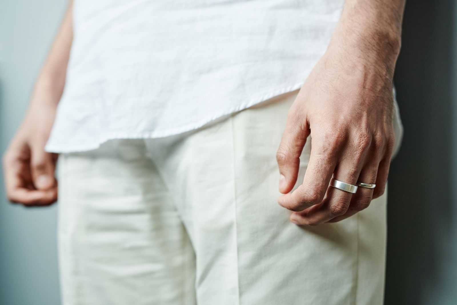 A person's relaxed hand wearing two plain metal rings, illustrating how discreet a smart ring looks day to day
