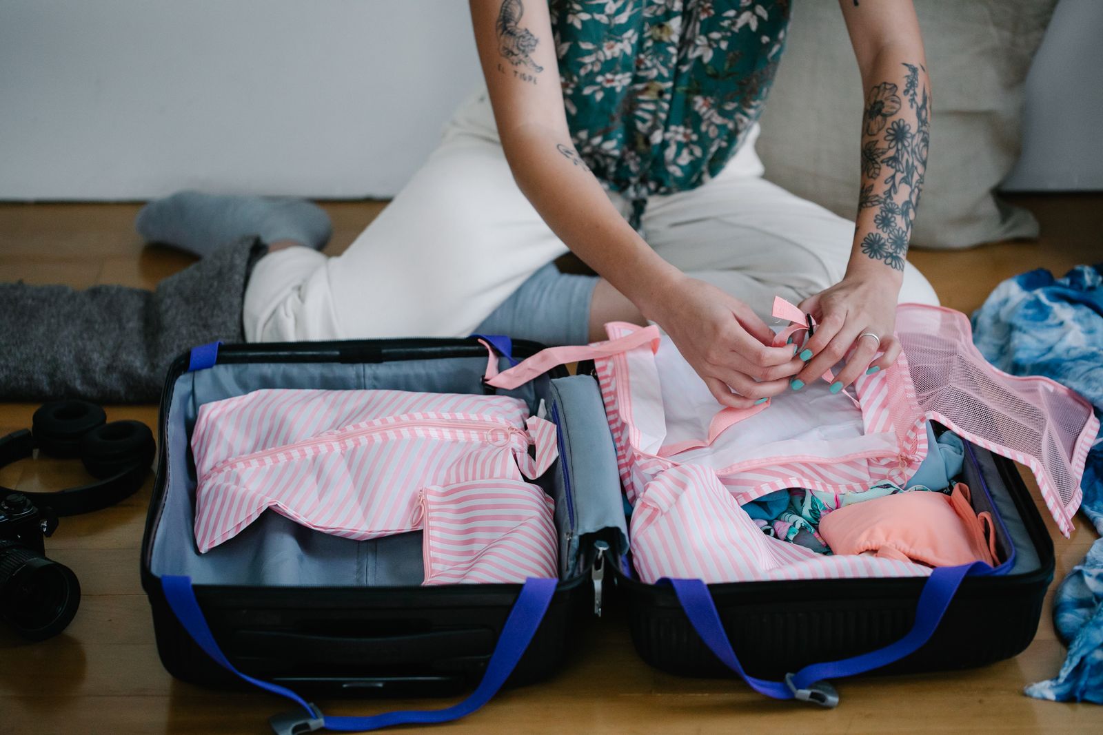 Person folding and packing clothes into a bag for a carry-on-only trip