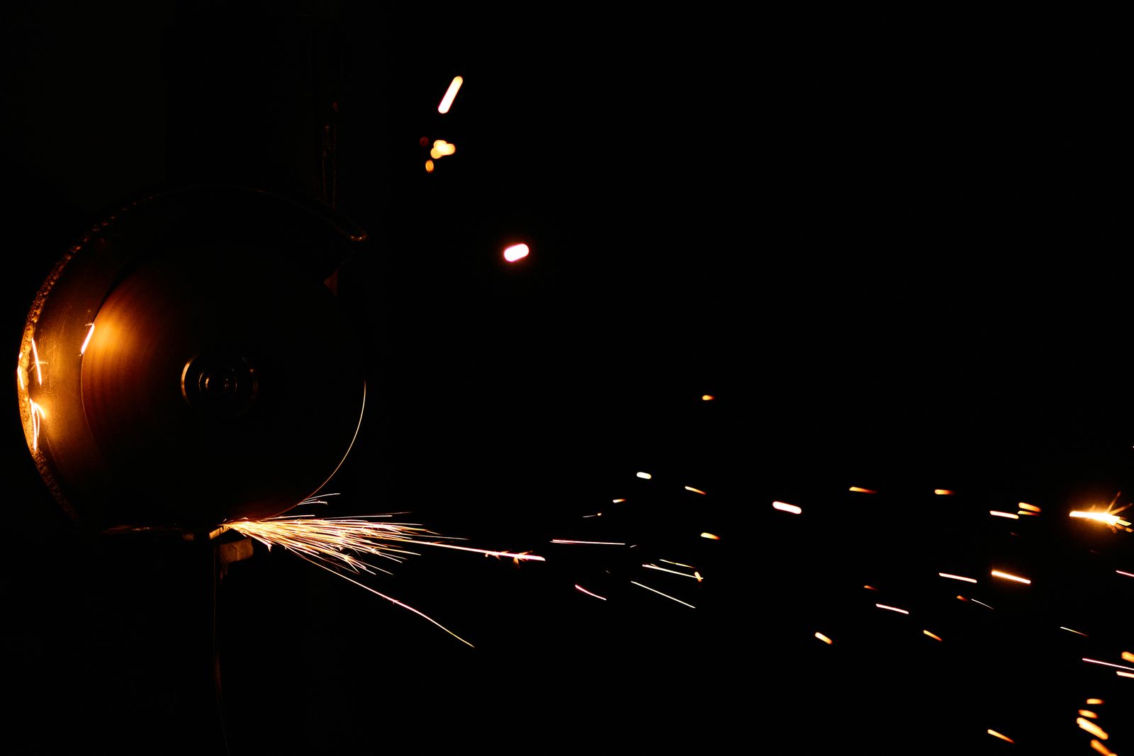 Sparks flying from a cordless angle grinder cutting metal