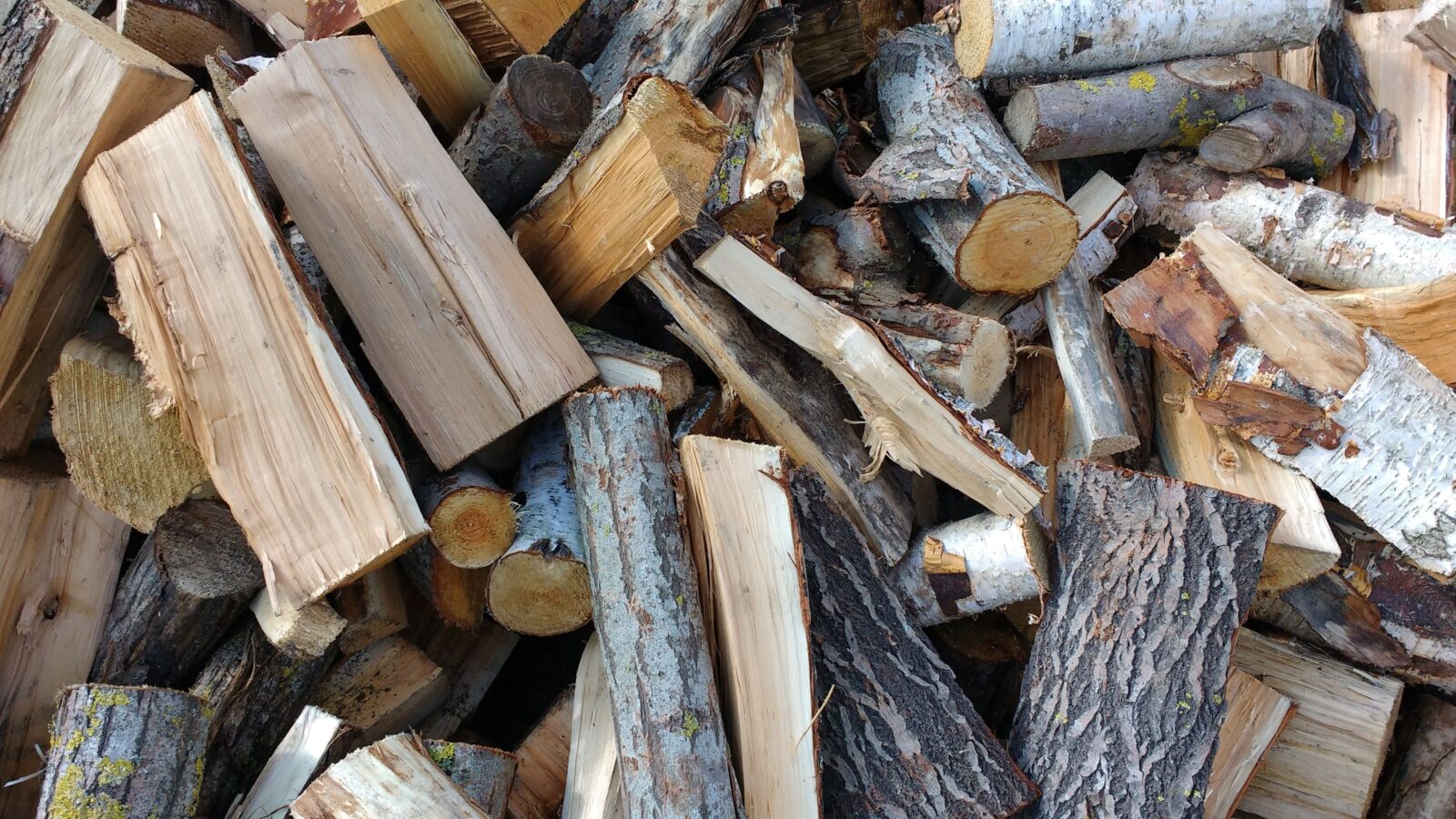 A stack of freshly split firewood, the kind of pile a log splitter turns rounds into for winter burning.