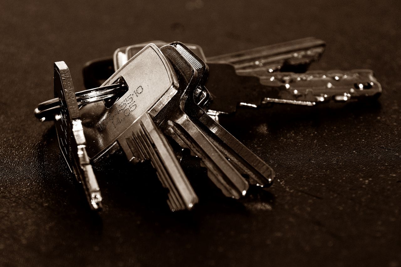A ring of house keys on a dark table