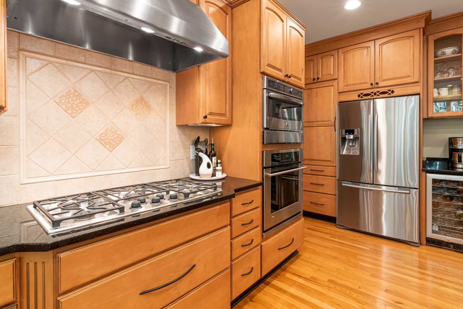 Kitchen with a gas cooktop, two wall ovens and a stainless steel refrigerator