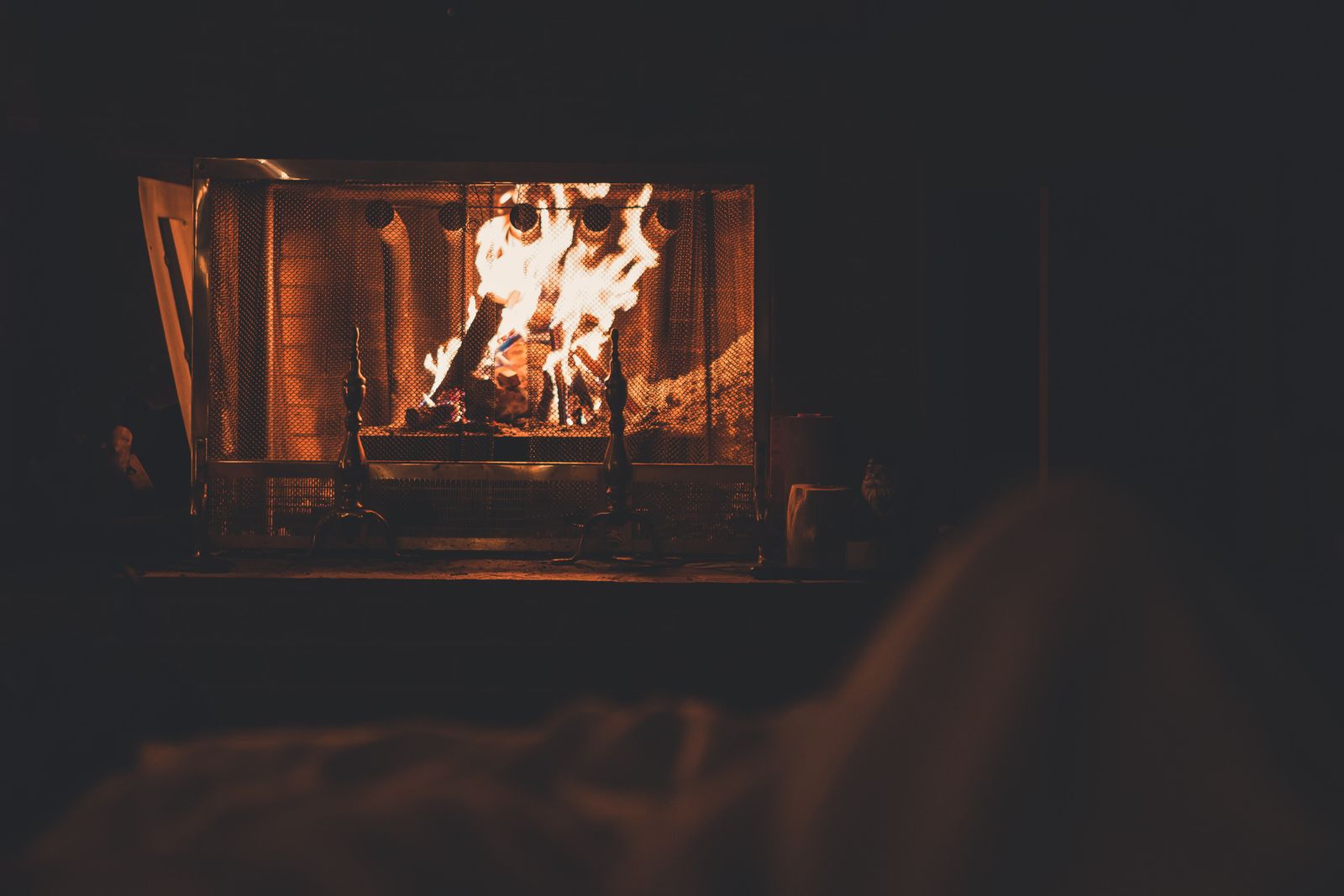 Orange flames burning on logs inside a fireplace in a dark room