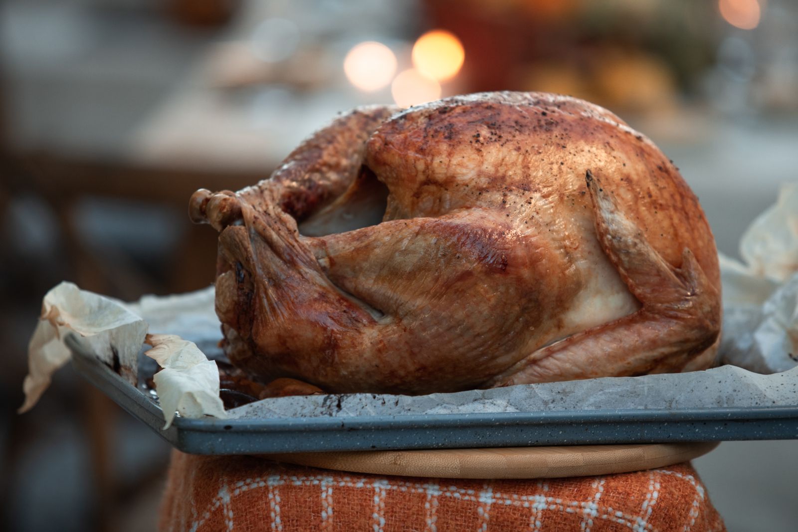 Roasted turkey resting on a gray speckled tray lined with parchment paper